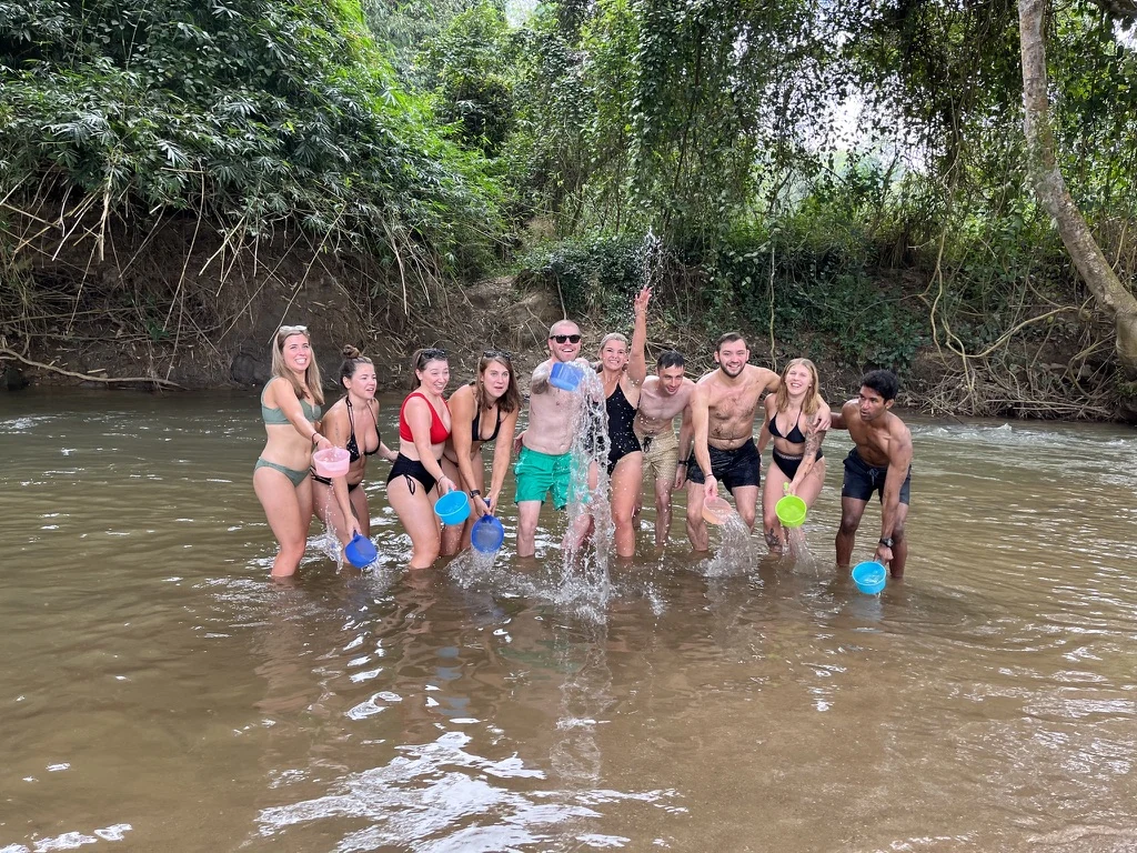 Guests splashing in the river after giving the elephants a bath