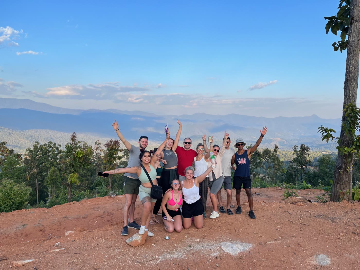 A tour group celebrating together at a mountain viewpoint
