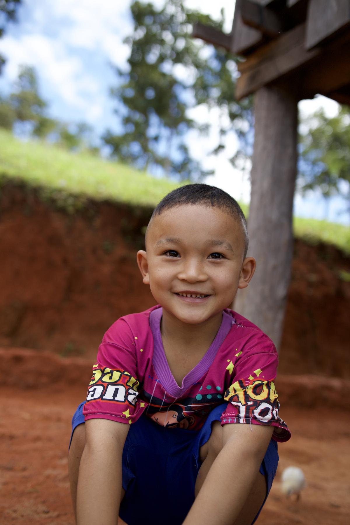 A young village boy smiling at the camera