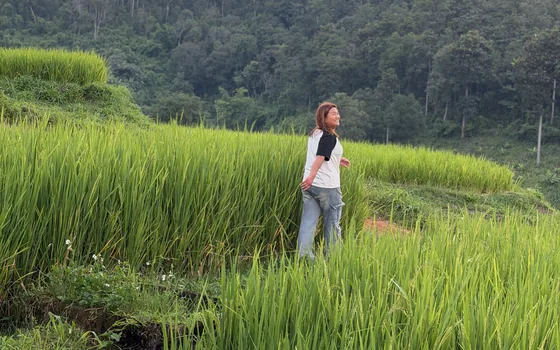 A villager walking among vivid green rice fields