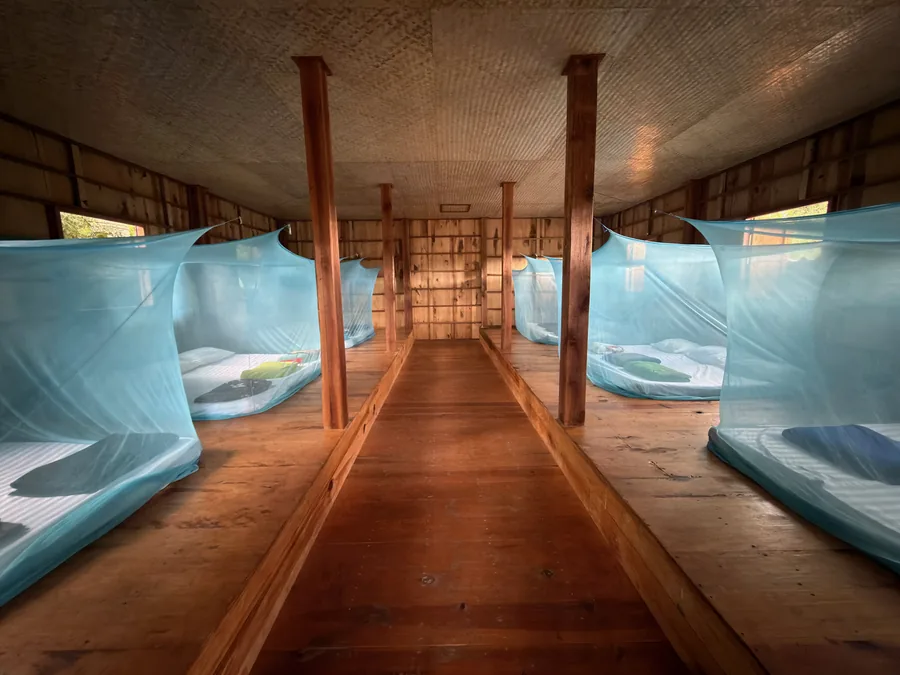Rows of netted beds on both sides of the longhouse aisle
