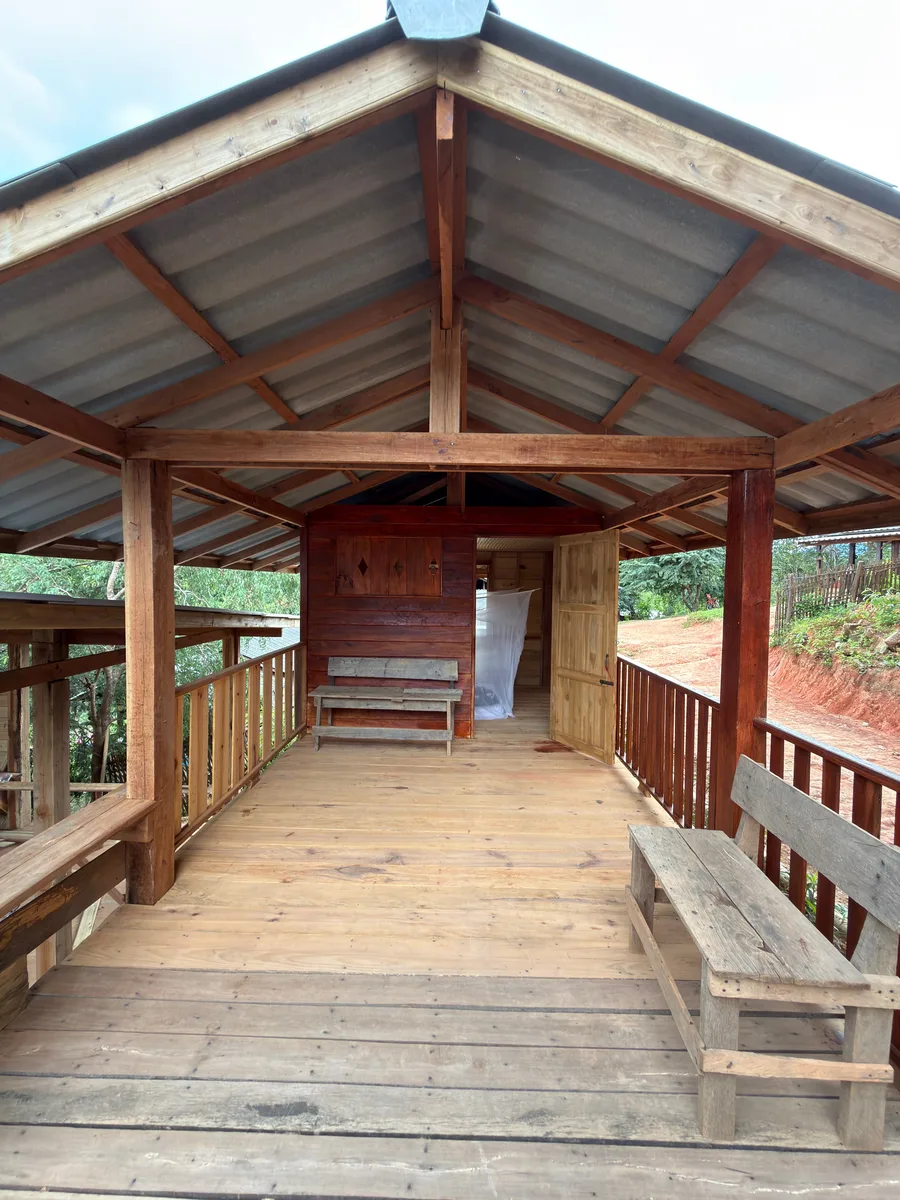 Open wooden lodge porch looking into the surrounding greenery